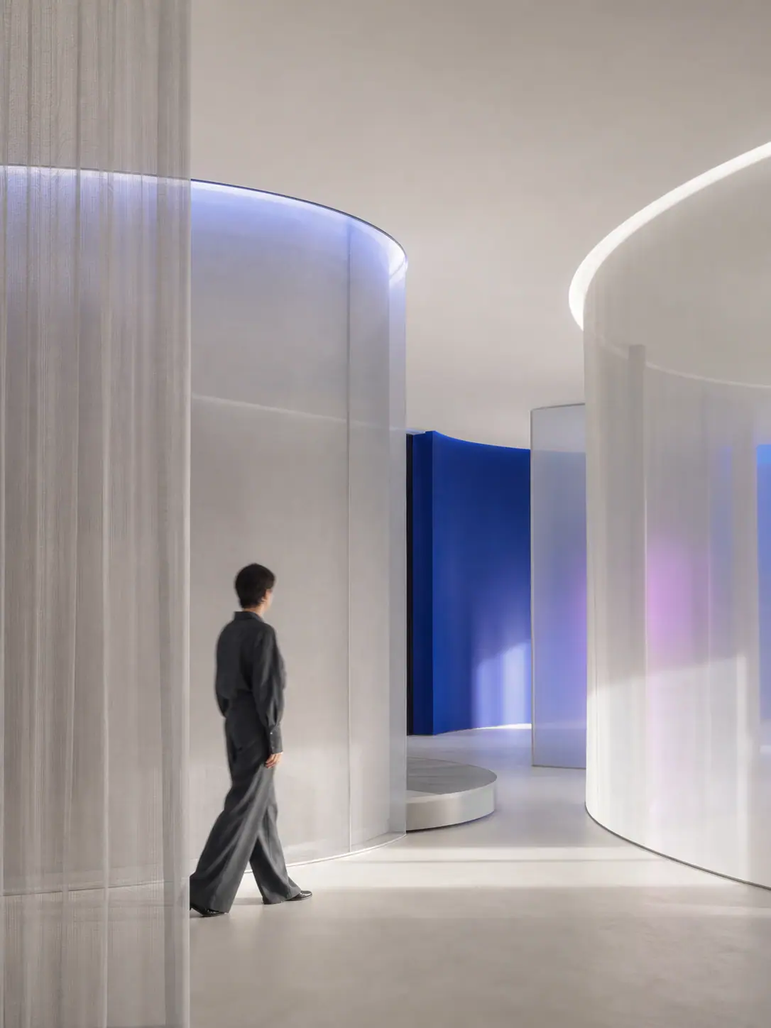 A person walking through an adaptive interior of translucent curved partitions
